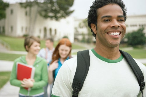 Smiling students walking across a campus